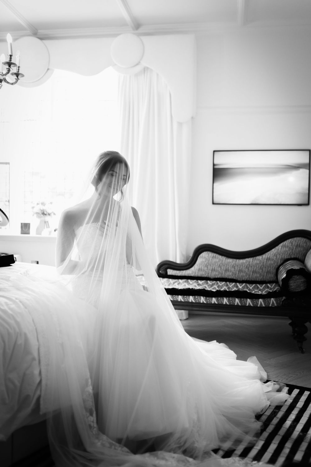 A dramatic black and white photo series of a wedding dress flowing over an antique chaise lounge.