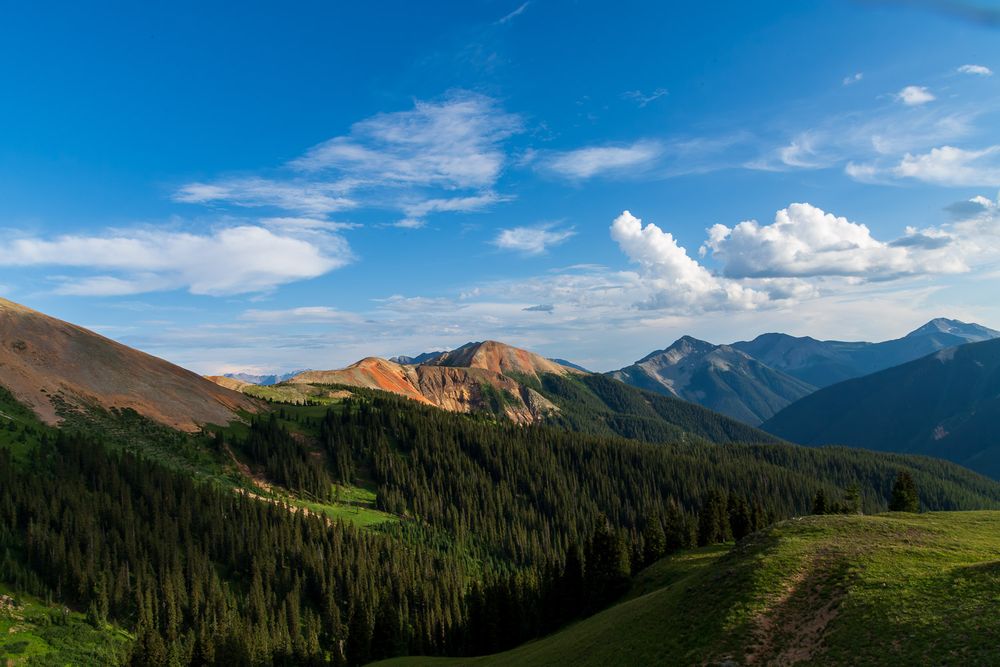 Scenic mountain landscape with pine forests, red peaks, and blue sky in Colorado. San Juan Mountains Colorado