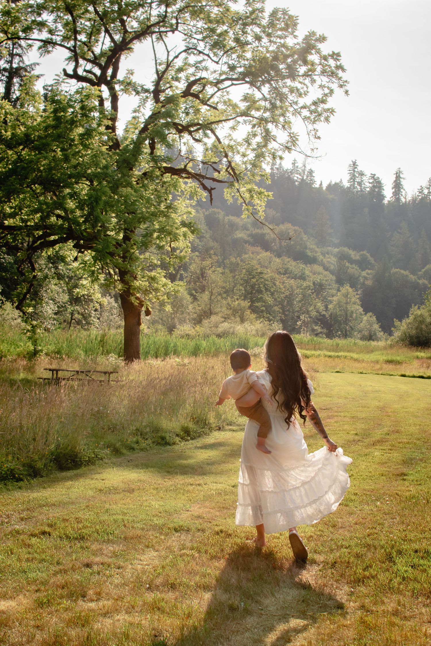 Mother walking with toddler through a golden field during family session near Seattle