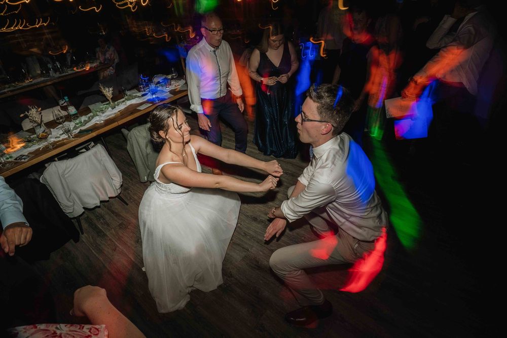 Wedding reception dance floor with colorful lighting and celebration.