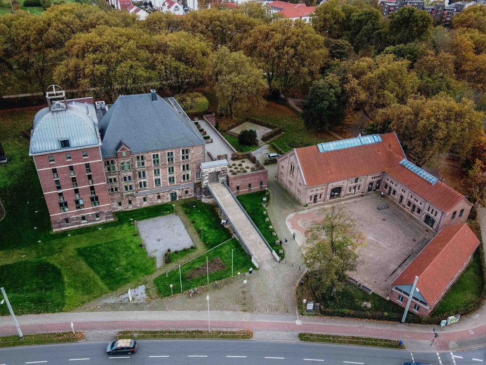 Aerial view of historic German castle complex with red roofs and courtyard.