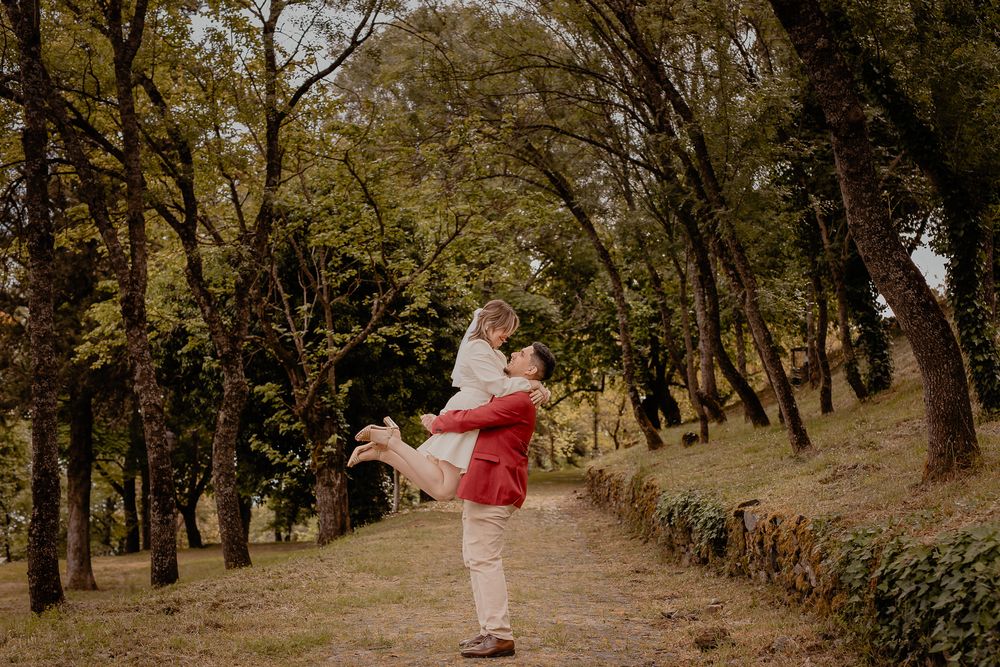 A romantic moment captured between two people on a wooded path during fall.
