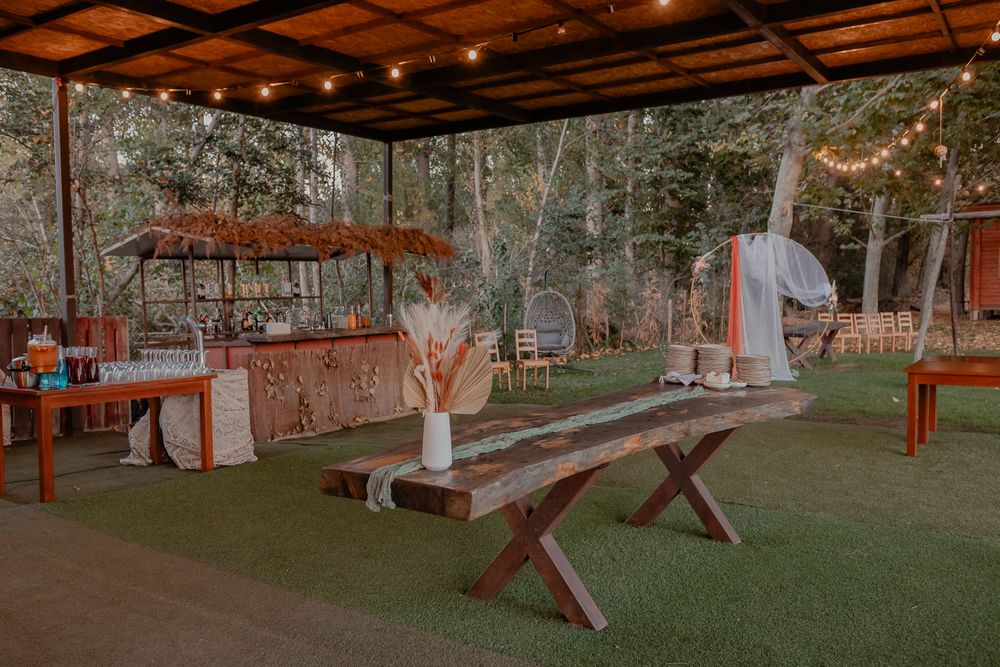 Rustic outdoor wedding venue with wooden benches and natural decor.