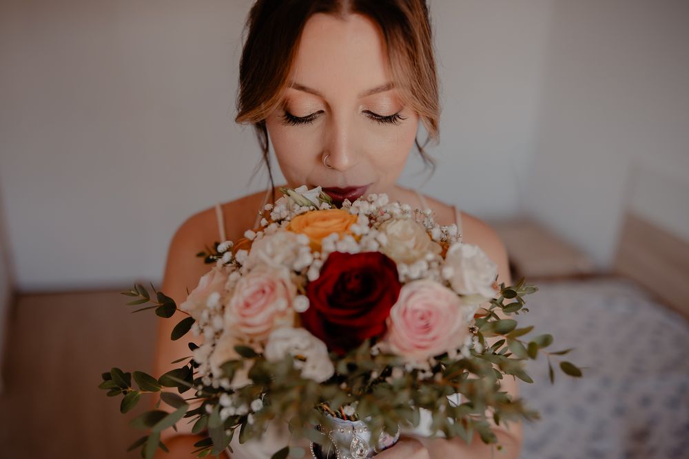 Beautiful wedding bouquet with pink and white roses and greenery against a soft blurred background.