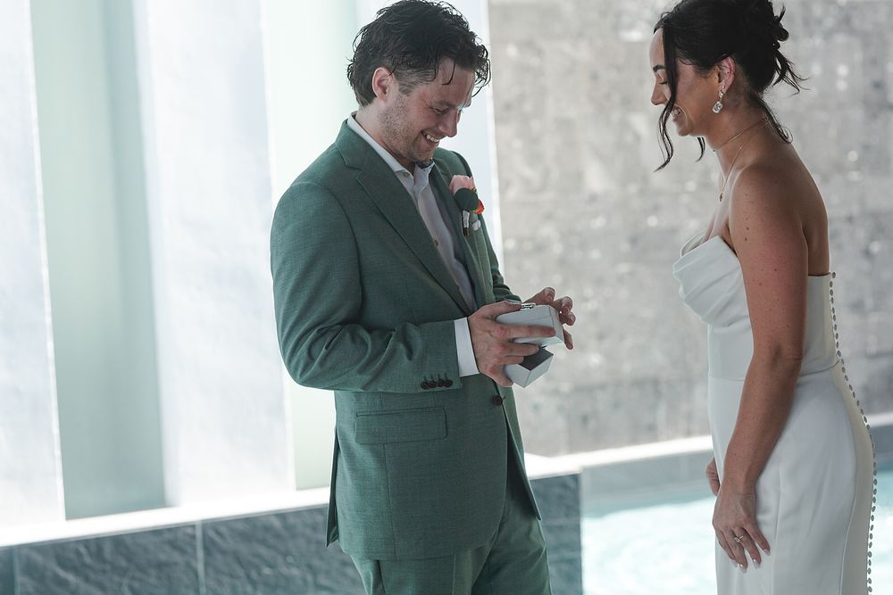 A couple shares intimate moments under an elegant covered walkway with white columns at Majestic Elegance Costa Mujeres.
