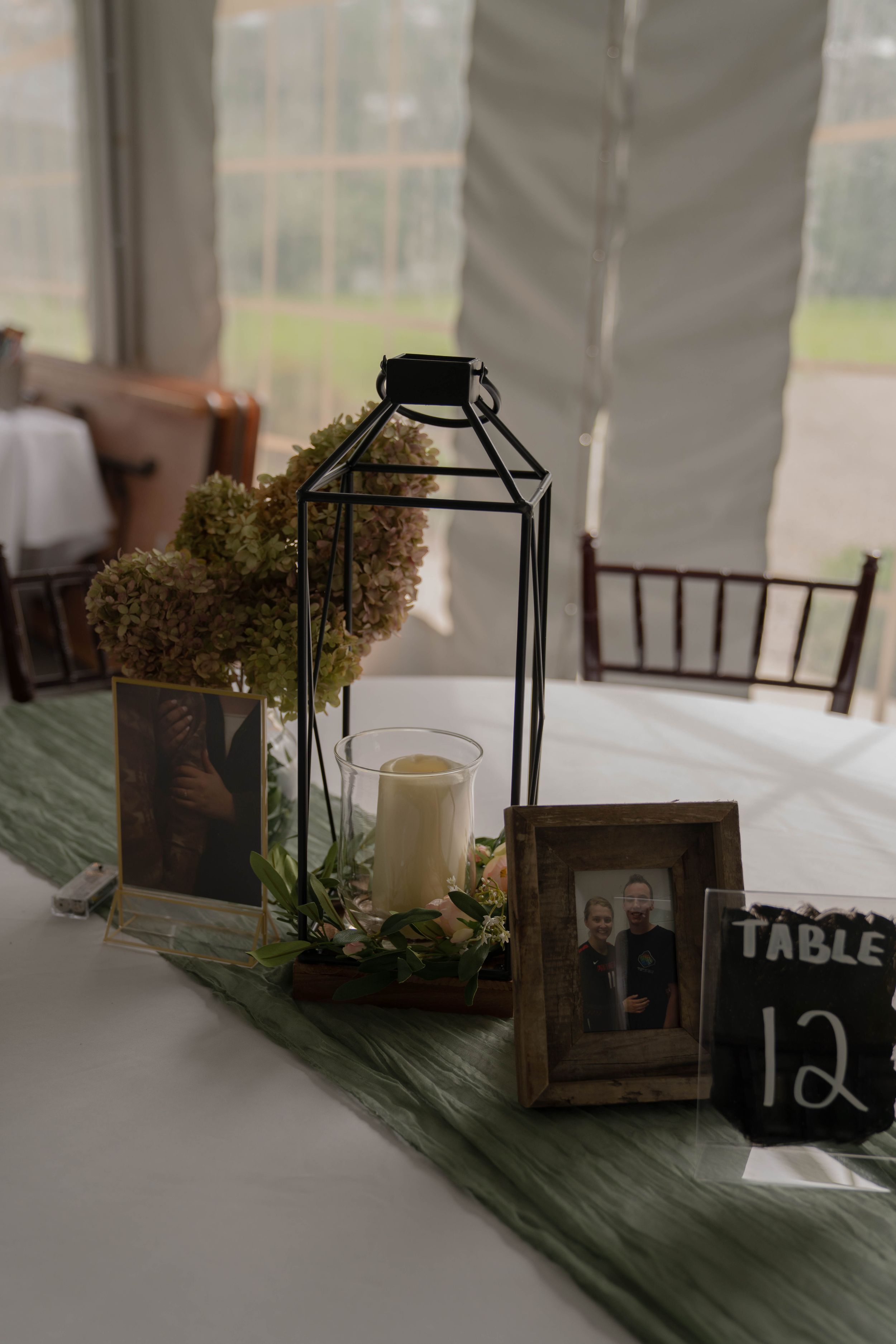 Rustic wedding table decor with table numbers, lanterns and wooden crates.