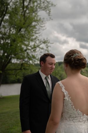 Couple sharing an intimate moment by a lake during their wedding.