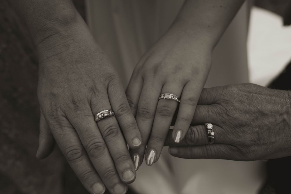 Close-up shots of hands with wedding rings in black and white.