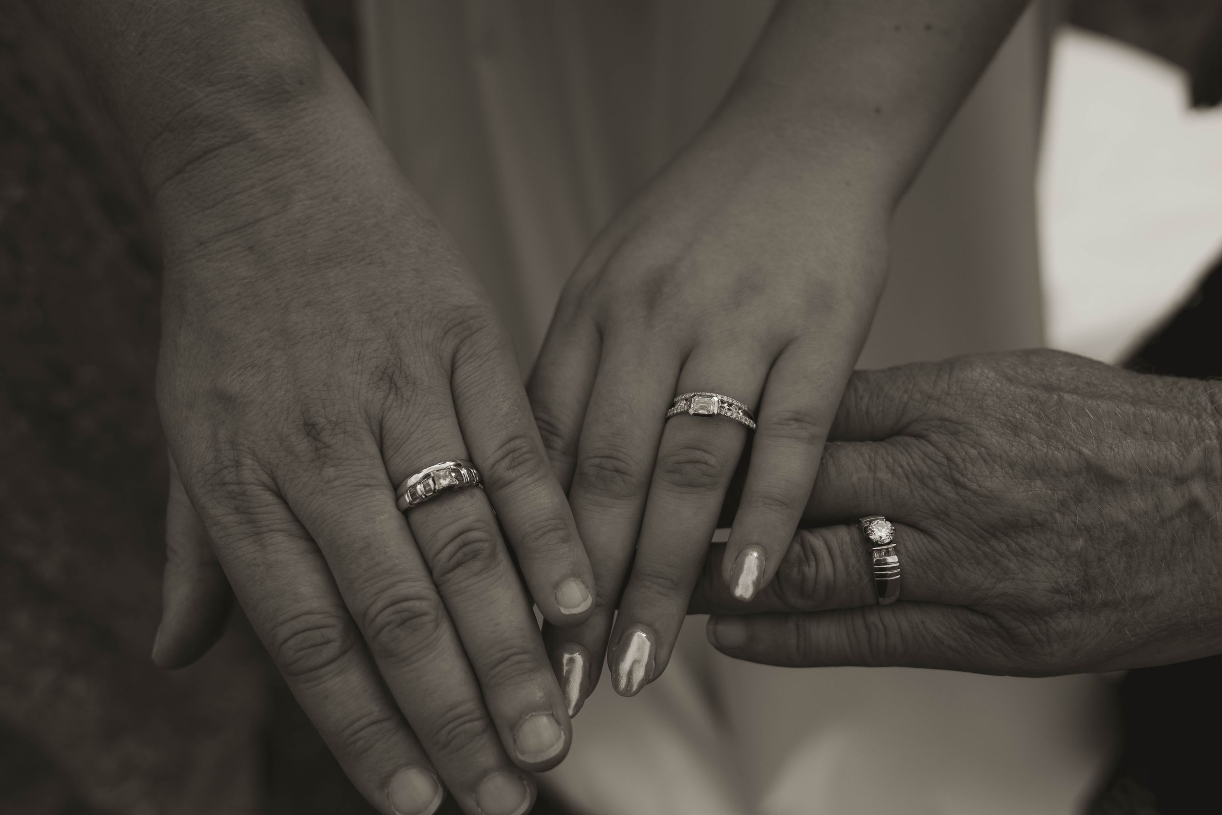 Close-up shots of hands with wedding rings in black and white.