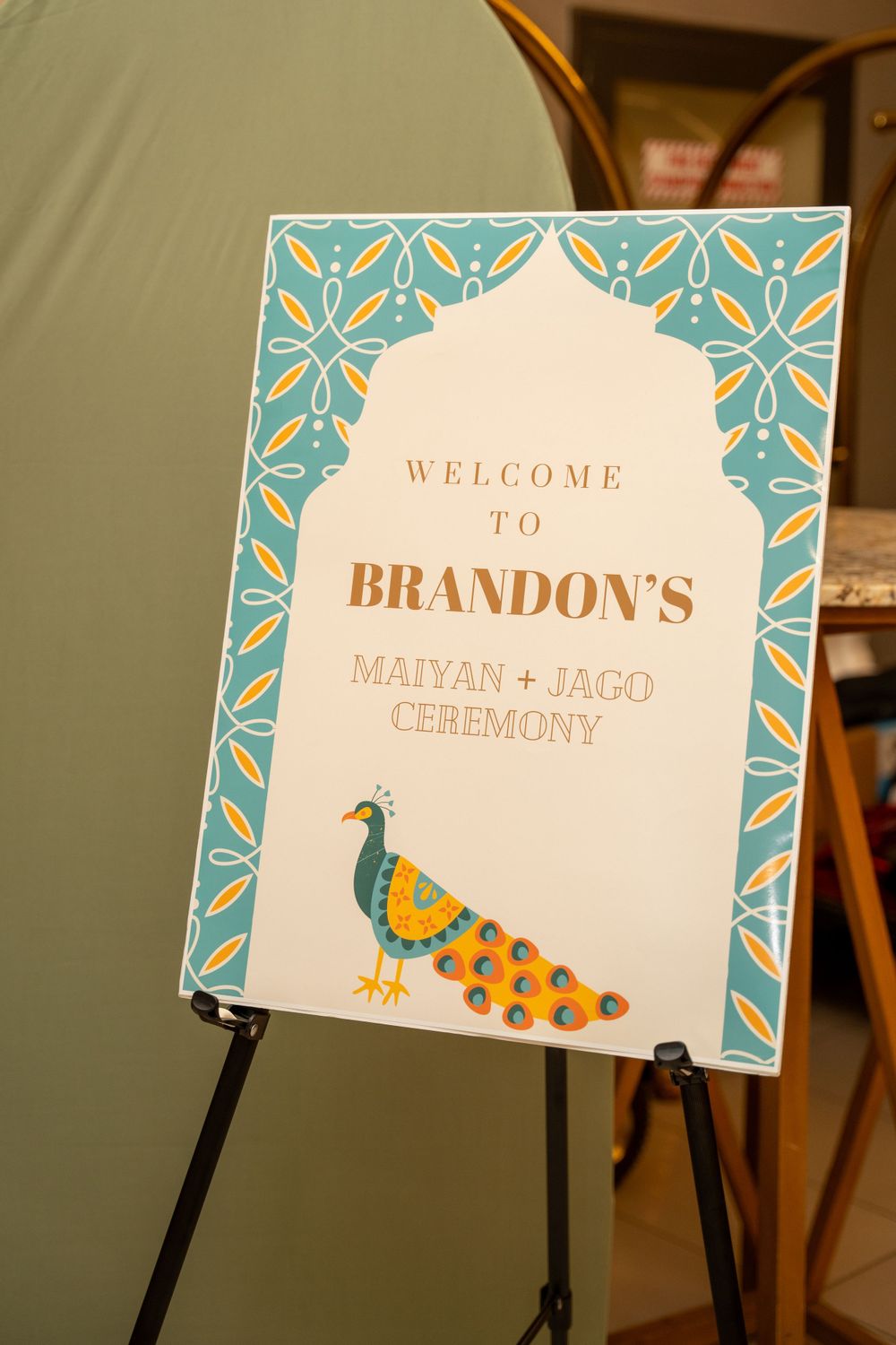 Elegant welcome sign for Brandon's Maiyan and Jago ceremony featuring a peacock design in blue and gold.