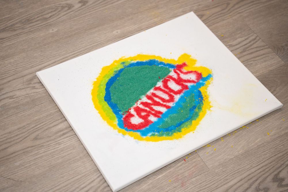 Colorful rangoli art design on a white surface showing vibrant circular patterns.
