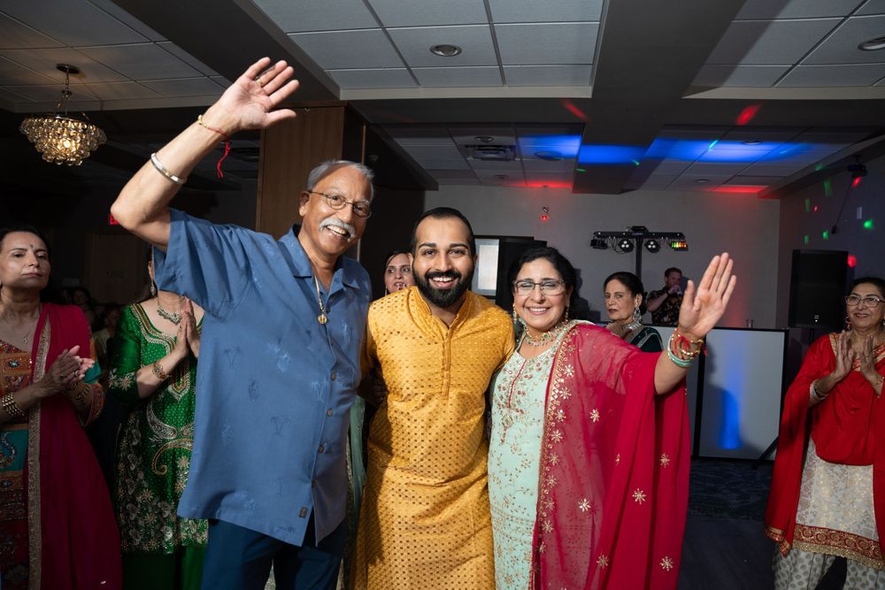 Celebratory moment during an Indian wedding reception with guests in traditional attire.