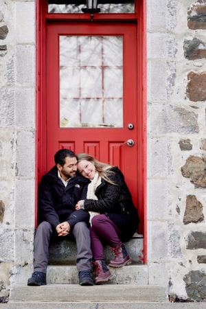 Couple amoureux assis près d'une porte rouge dans le vieux La Prairie Québec