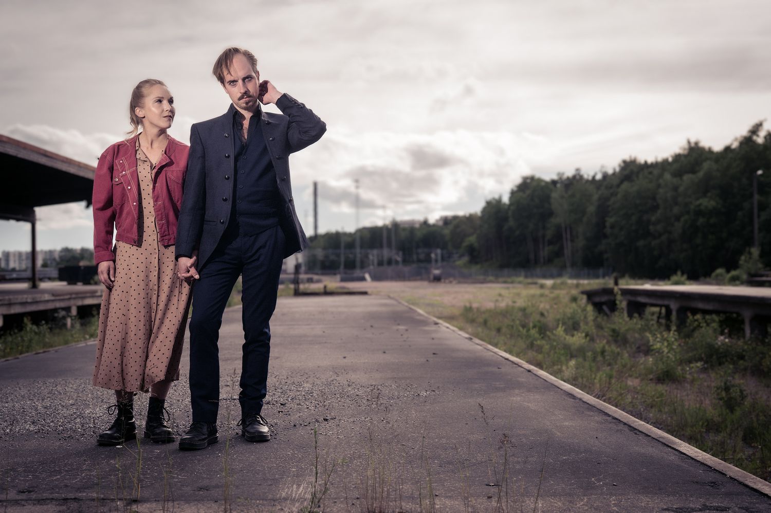 Pariskunta poseeraa kihlajaiskuvassa, teollisuusalueella Turussa.