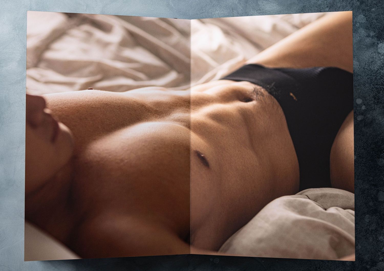 Full page spread of man in underwear captured during boudoir photo shoot.