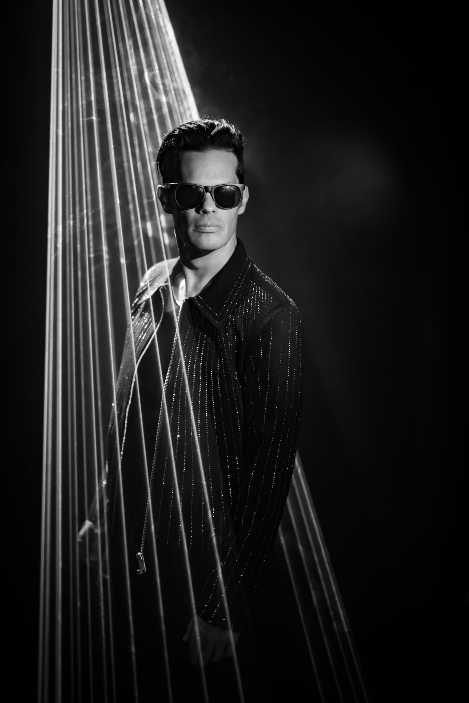 Black and white portrait with dramatic lighting and vertical line effects.