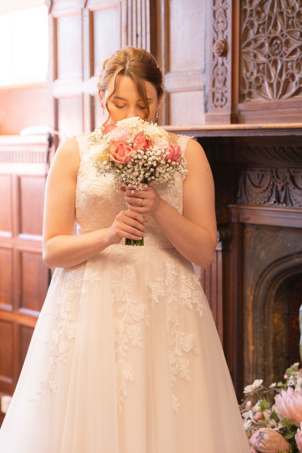 A bridal portrait of a bride smelling her wedding bouquet, with her eyes closed.