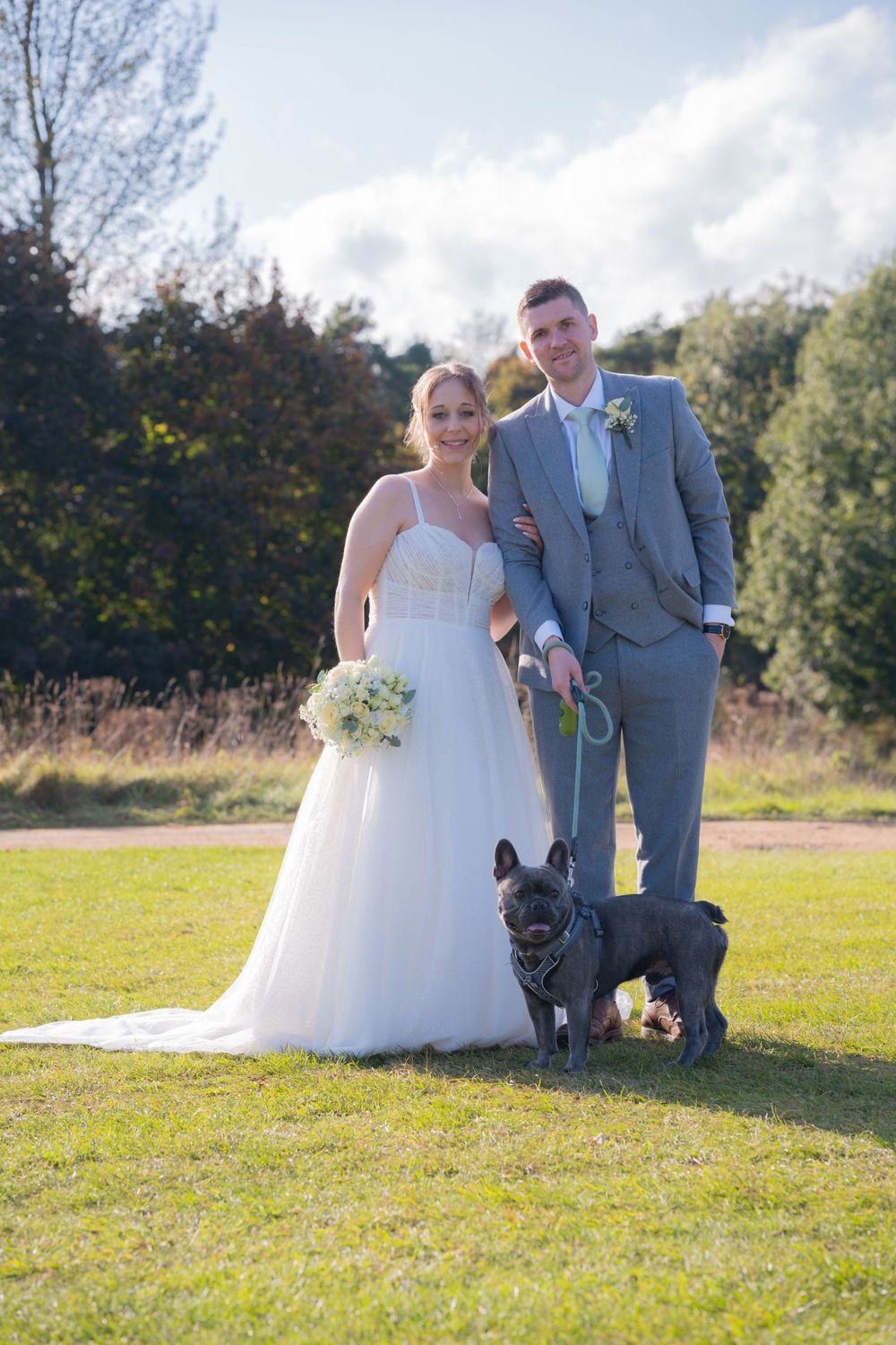 Couples portrait of bride and groom, together with their family dog.