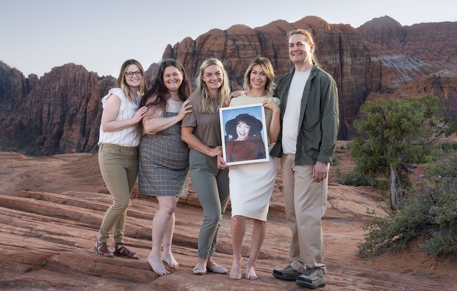 Five adult siblings standing and smiling