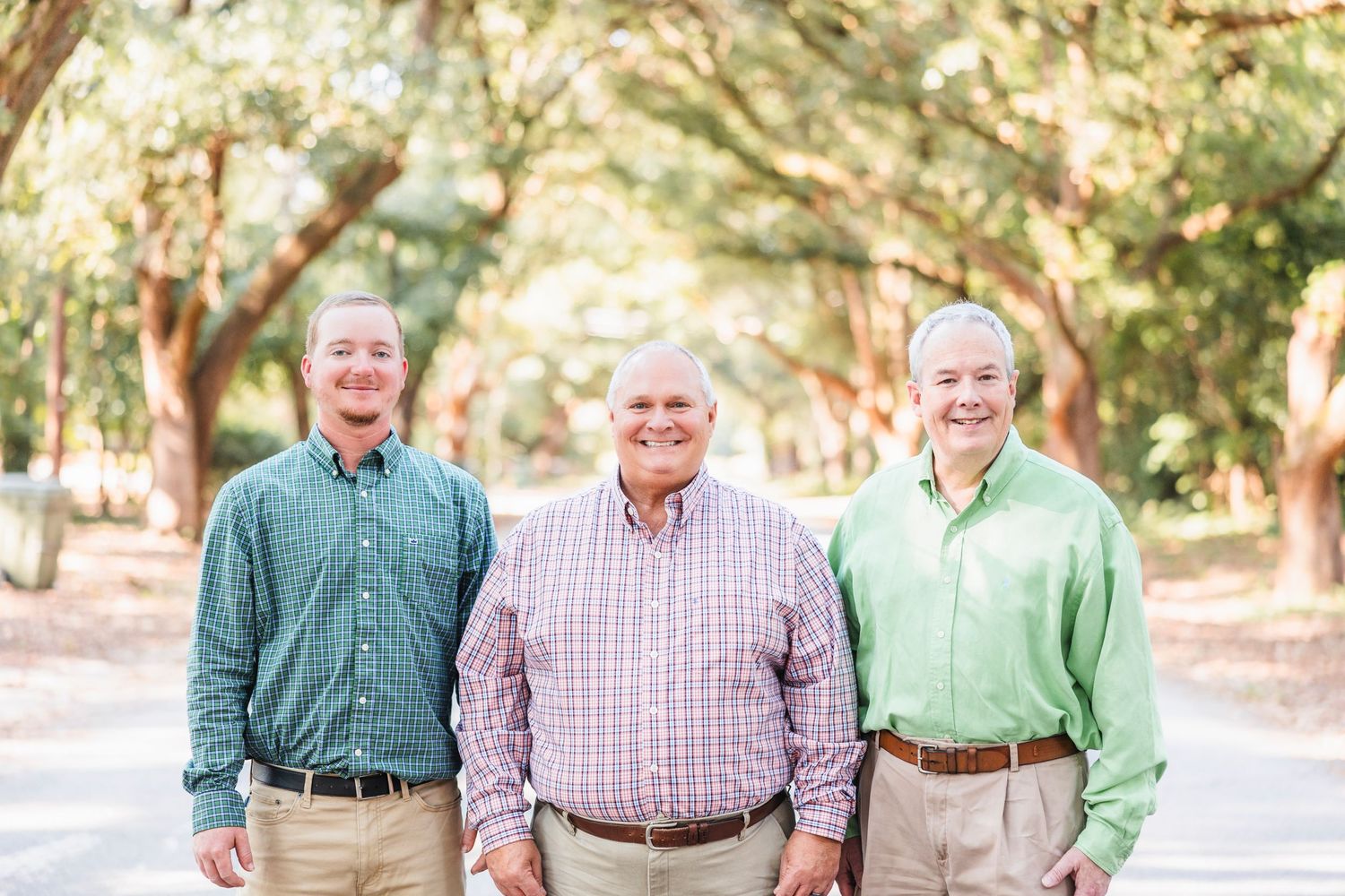 Group of people in coordinated pastel shirts smiling together outdoors.