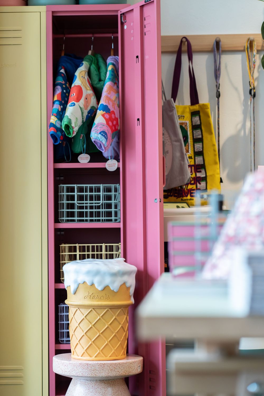 Pink vintage lockers with stuffed animals and decorative ice cream cone baskets provide retro storage charm.