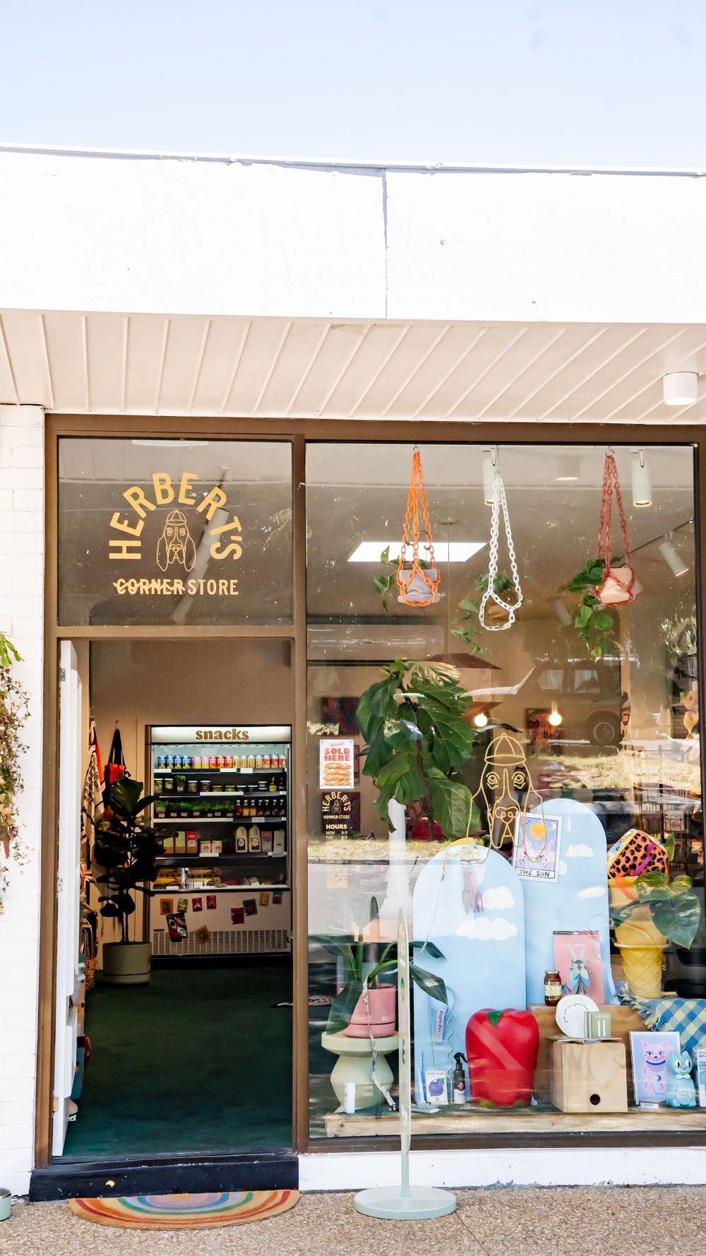 Storefront view of 'Herders' shop with vintage-style signage and window display featuring colorful lifestyle items and accessories.