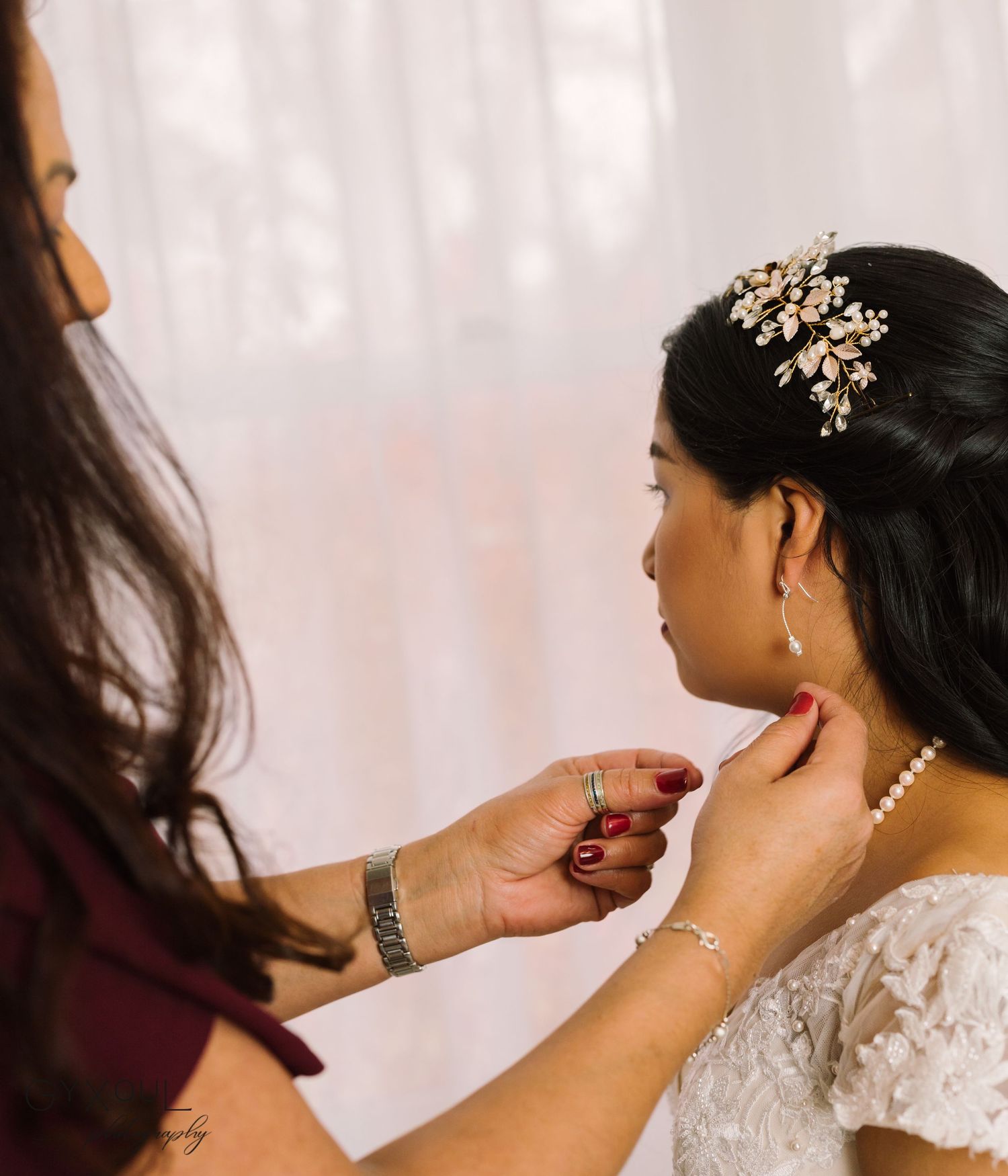 Getting ready scene with makeup being applied to bride wearing crystal headpiece.