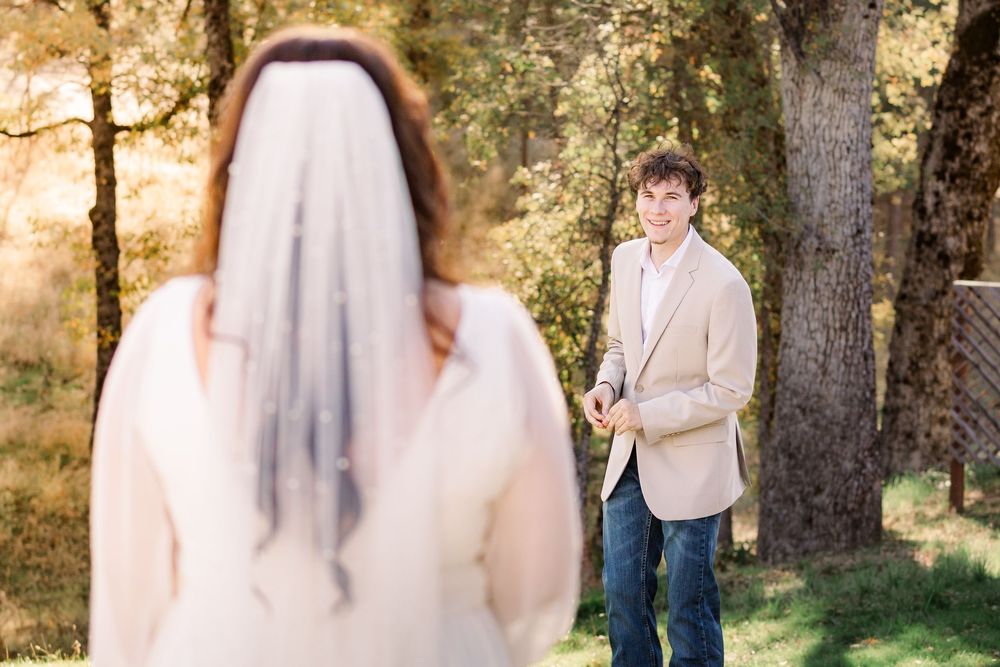 A couple poses together in a sunlit forest setting during a romantic autumn photoshoot.