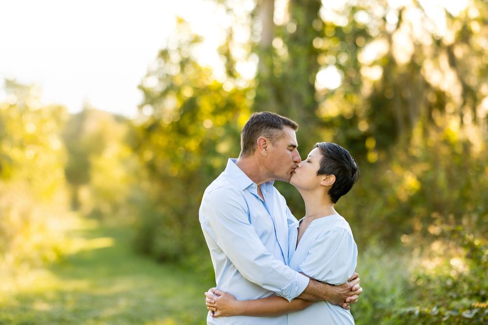 A romantic couple shares an intimate moment in a sunlit outdoor setting during golden hour.