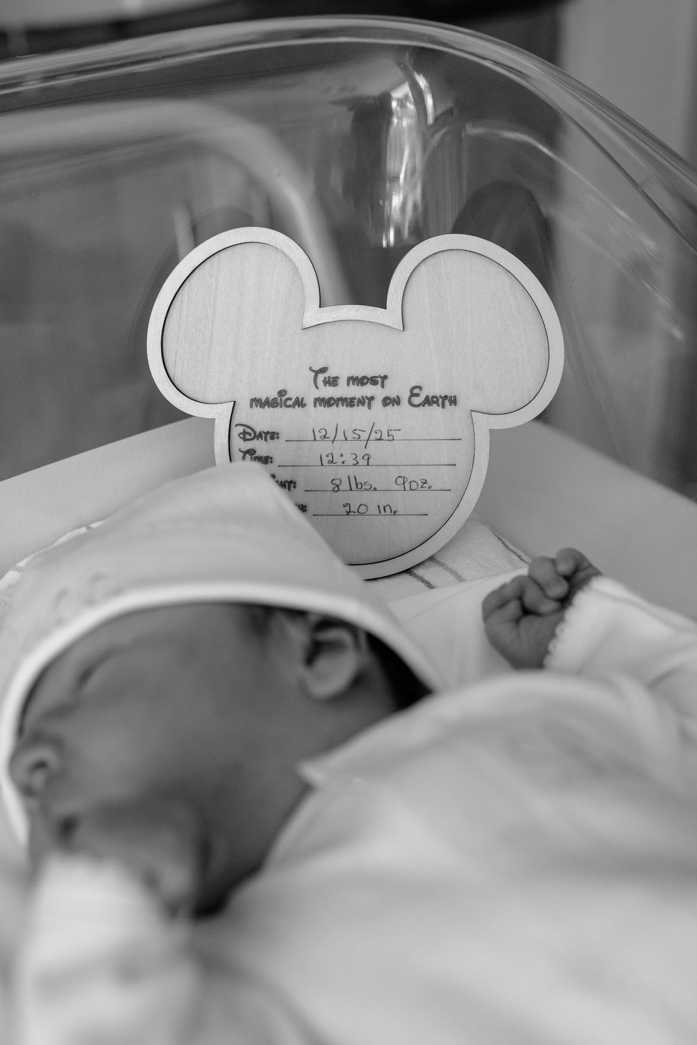 Black and white series of photos showing a baby's first moments in hospital with handwritten name cards visible.