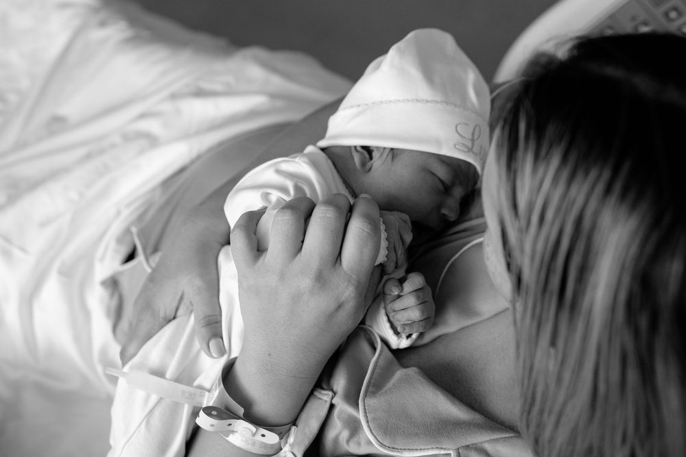 Close up view of a newborn baby resting in a hospital bed.