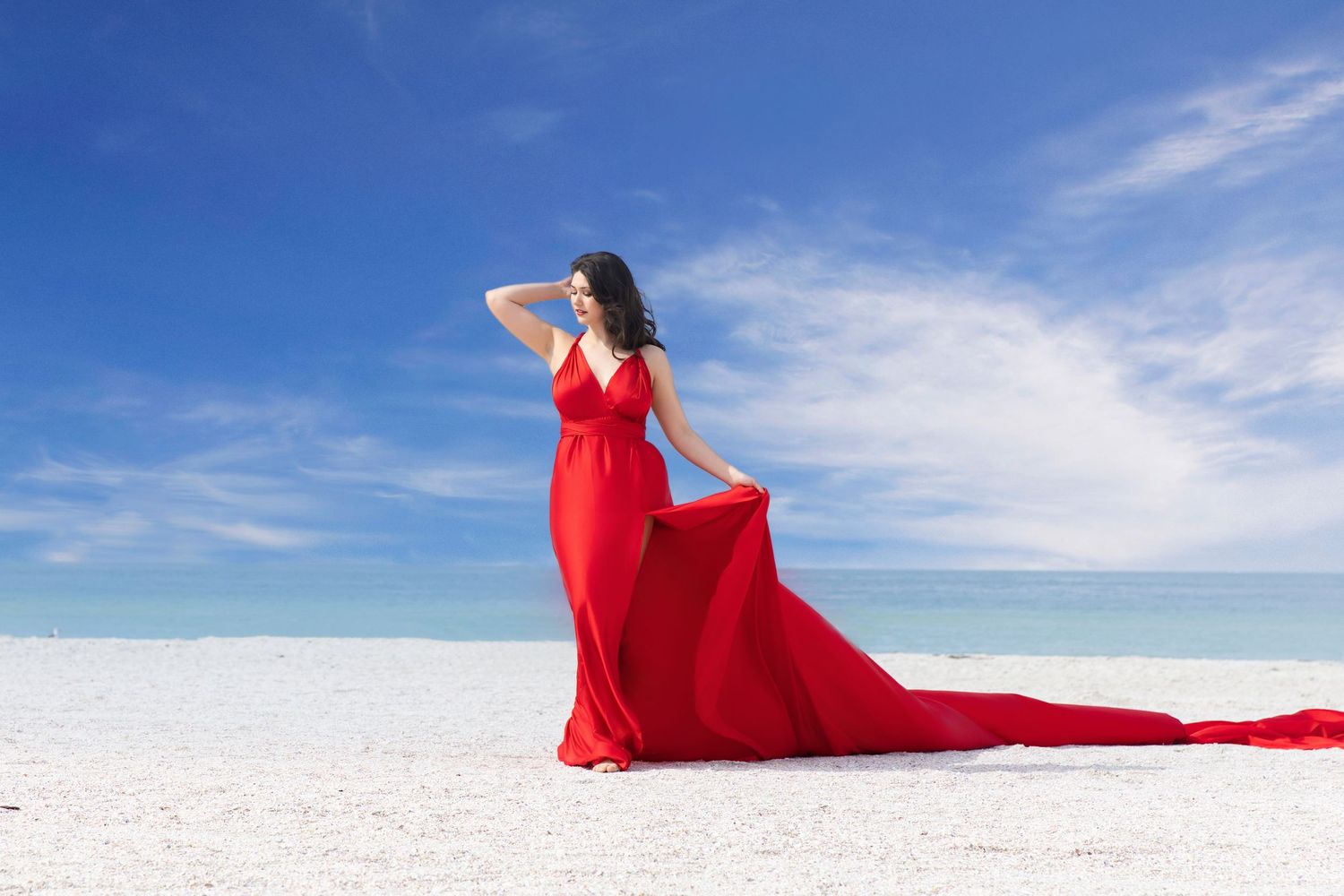 A flowing red dress billows dramatically against a stark white snowy landscape under a bright blue sky. Flying Dress Photoshoot