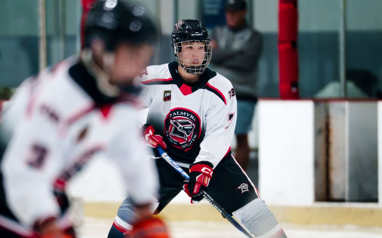 Palmyra Black Knights hockey player skating past opponent during game at York Ice Arena, York PA, by SportsFox Photography