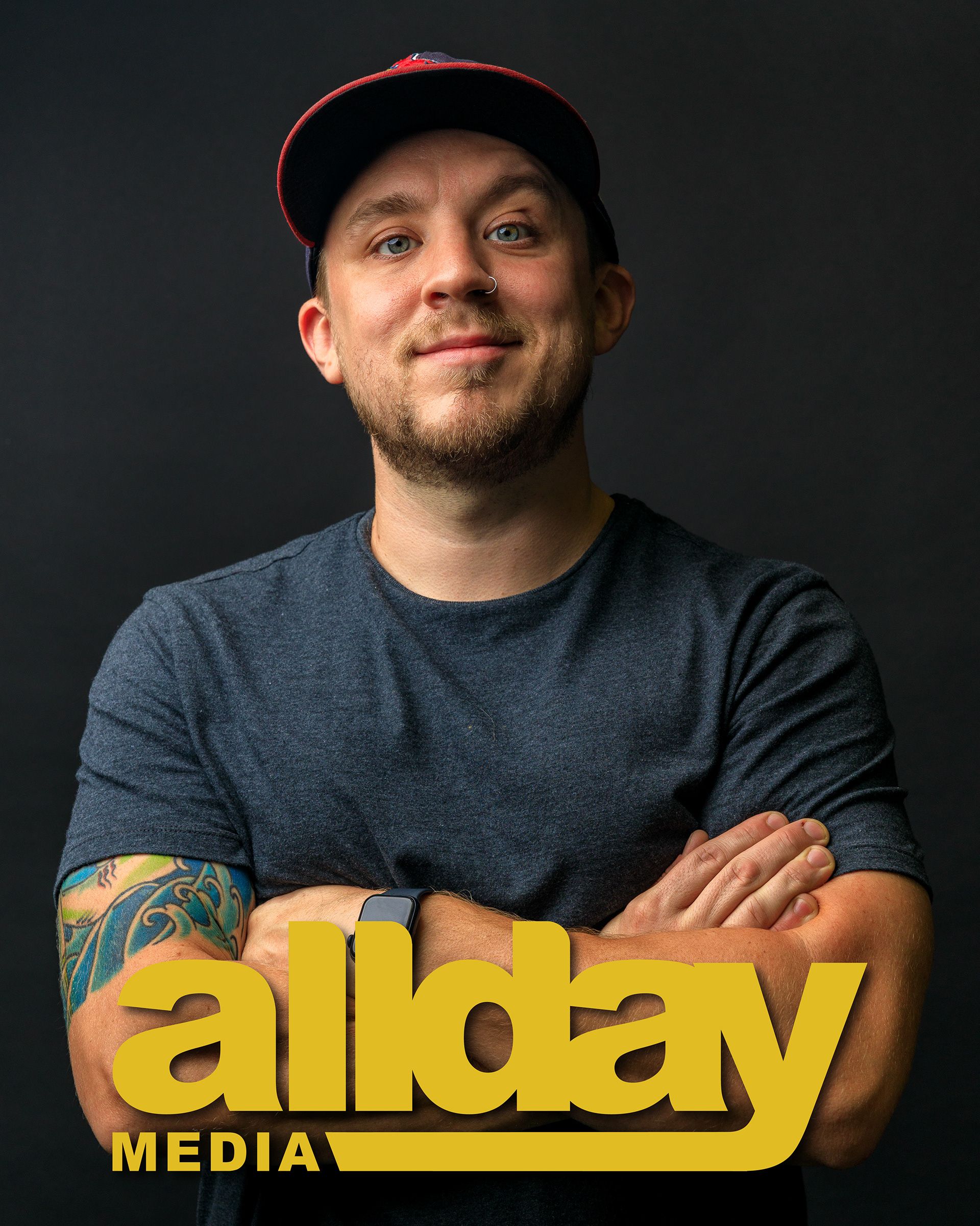 Professional headshots of person in black t-shirt against dark background with yellow company logo. photography st louis