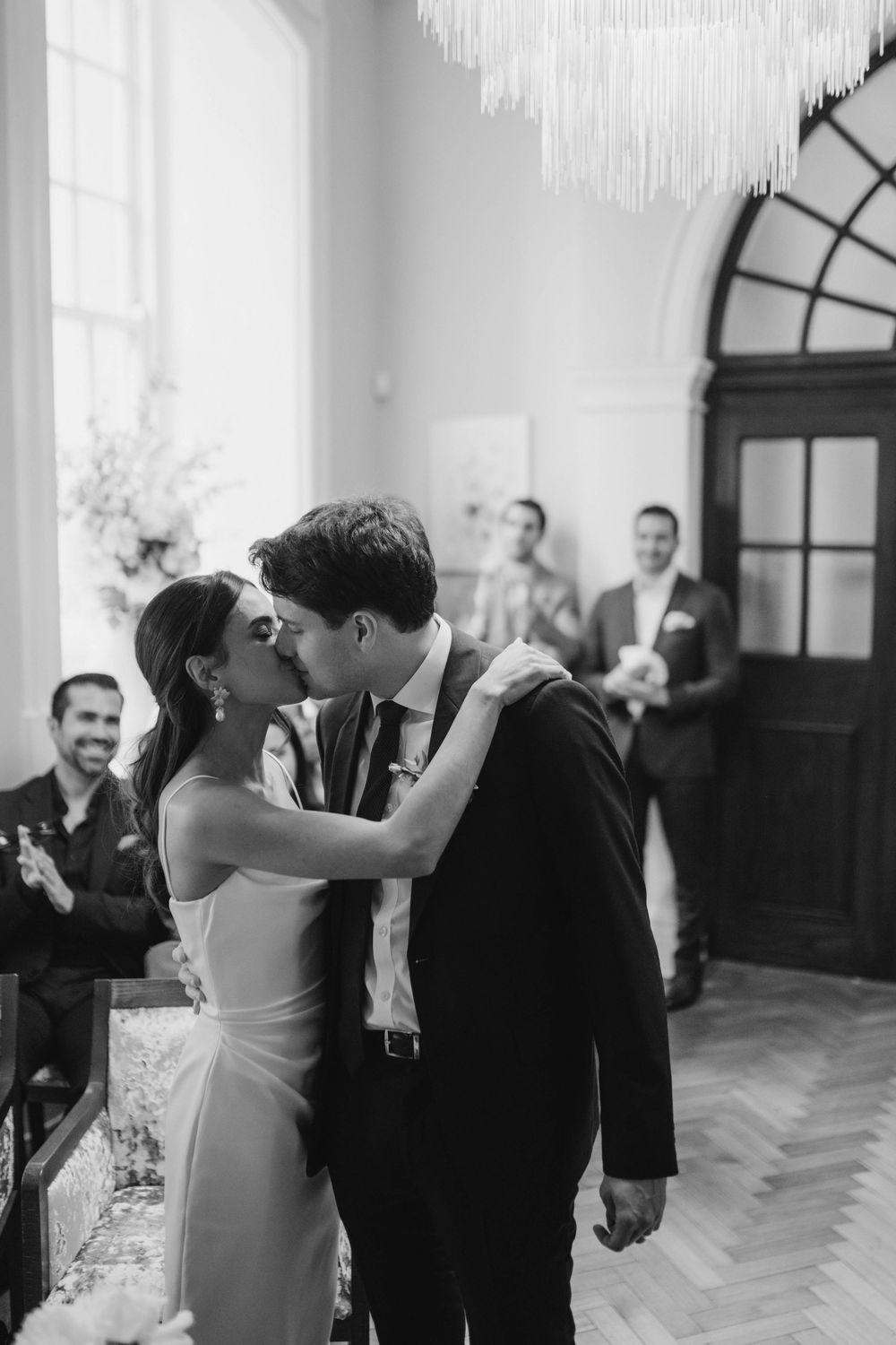 Black and white photo series of a couple sharing their first dance in an elegant indoor venue.