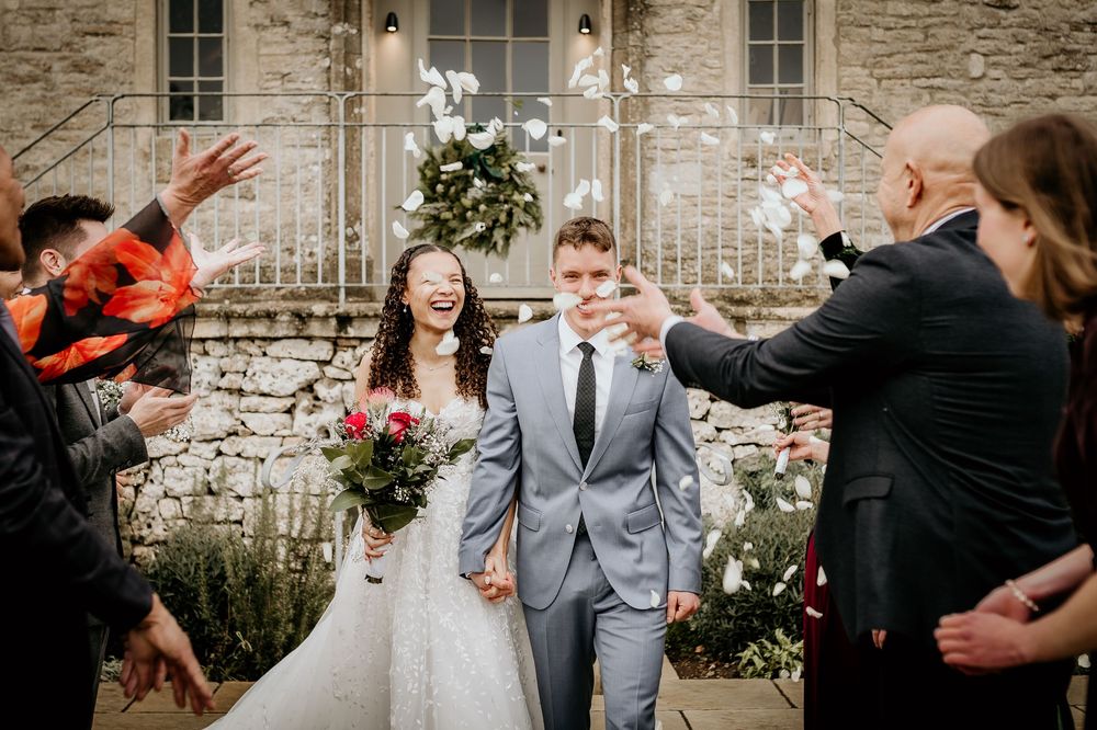Candid wedding party moments captured in black and white against a rustic stone wall backdrop.