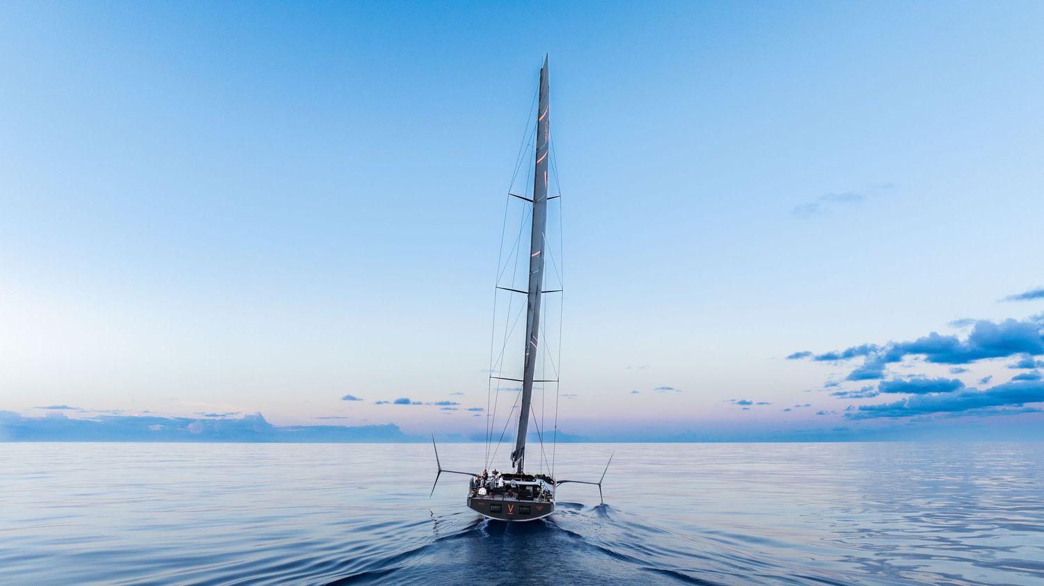 Panoramic view of a sailboat mast against a clear blue sky.