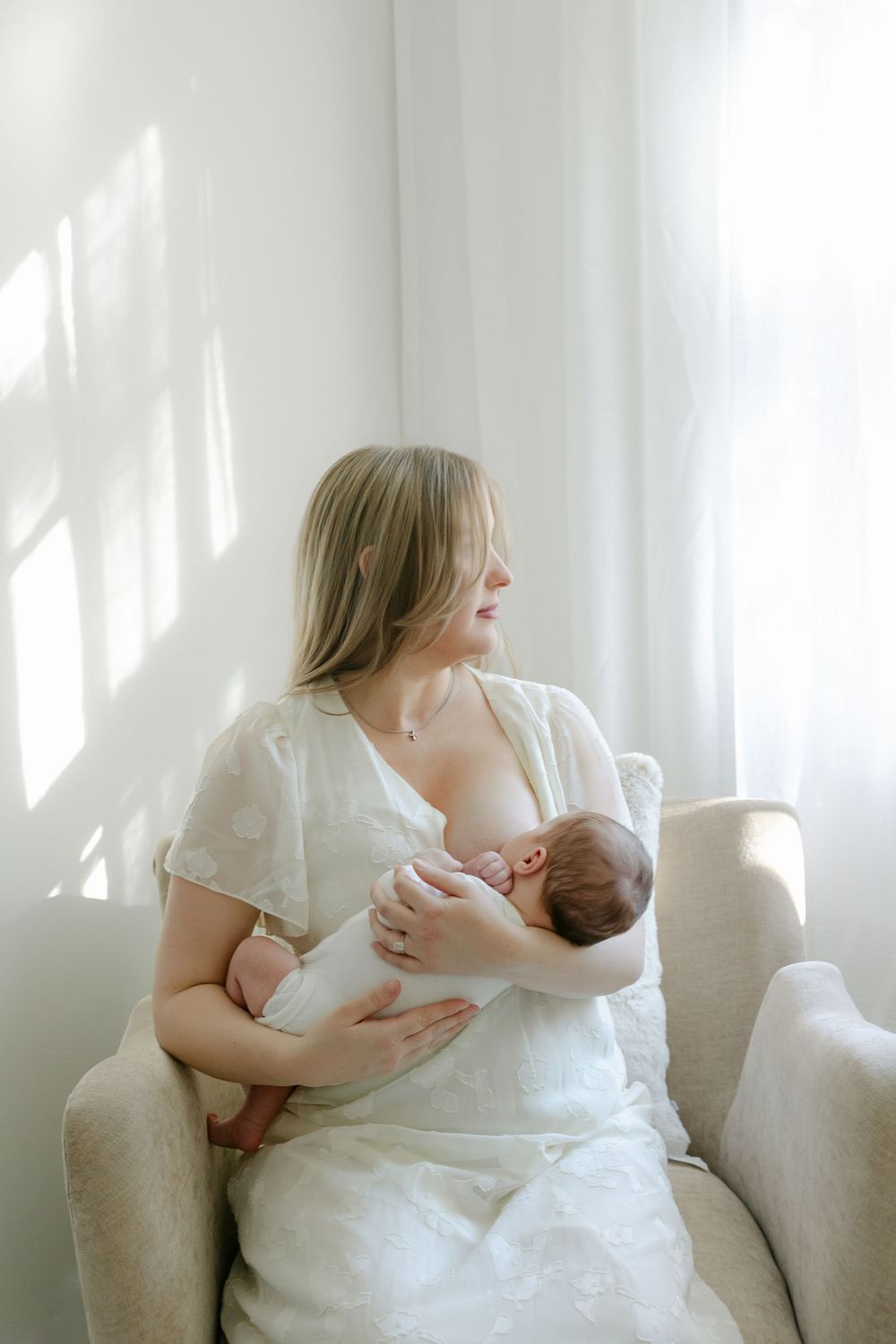 A series of intimate portraits showing tender moments with a newborn baby against a bright white backdrop.
