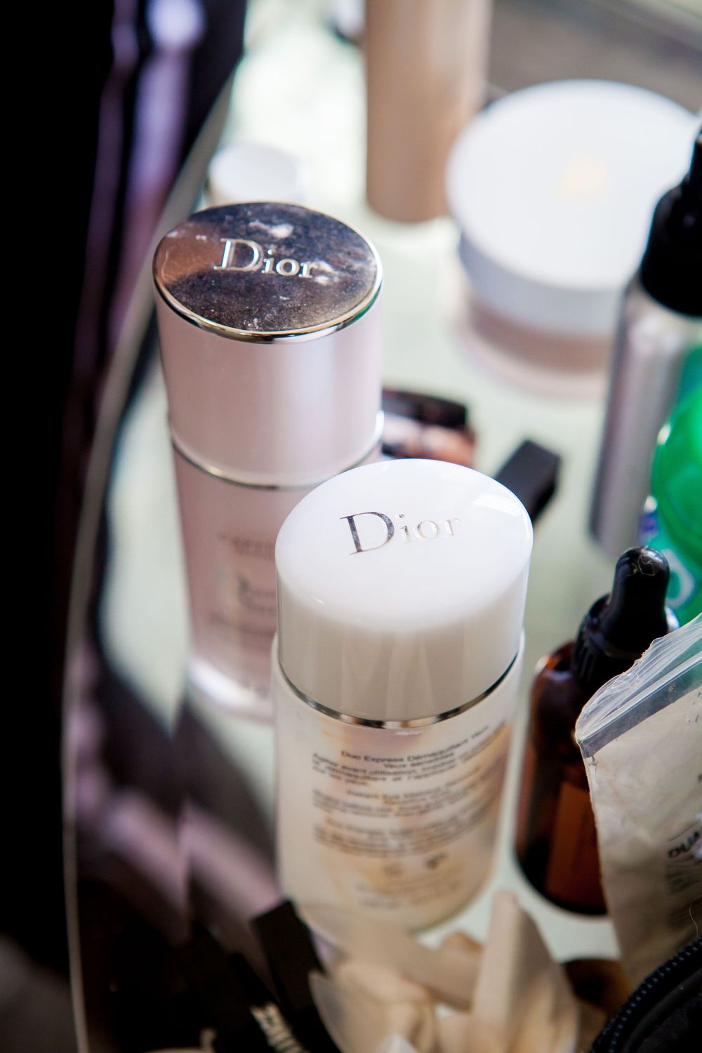 Close-up shot of Dior beauty products and cosmetics bottles arranged together.