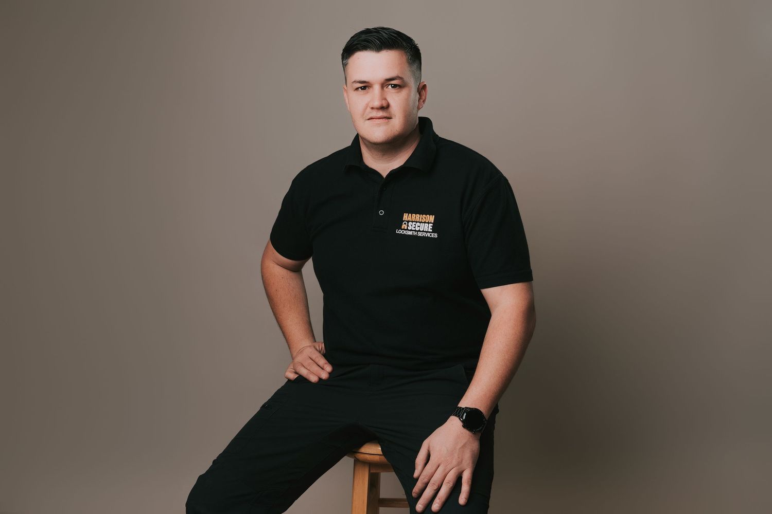 Professional studio portraits of someone in branded attire against a neutral gray background.