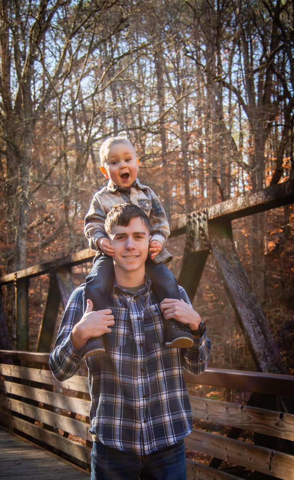 A joyful moment captured on a wooden bridge in autumn woods.