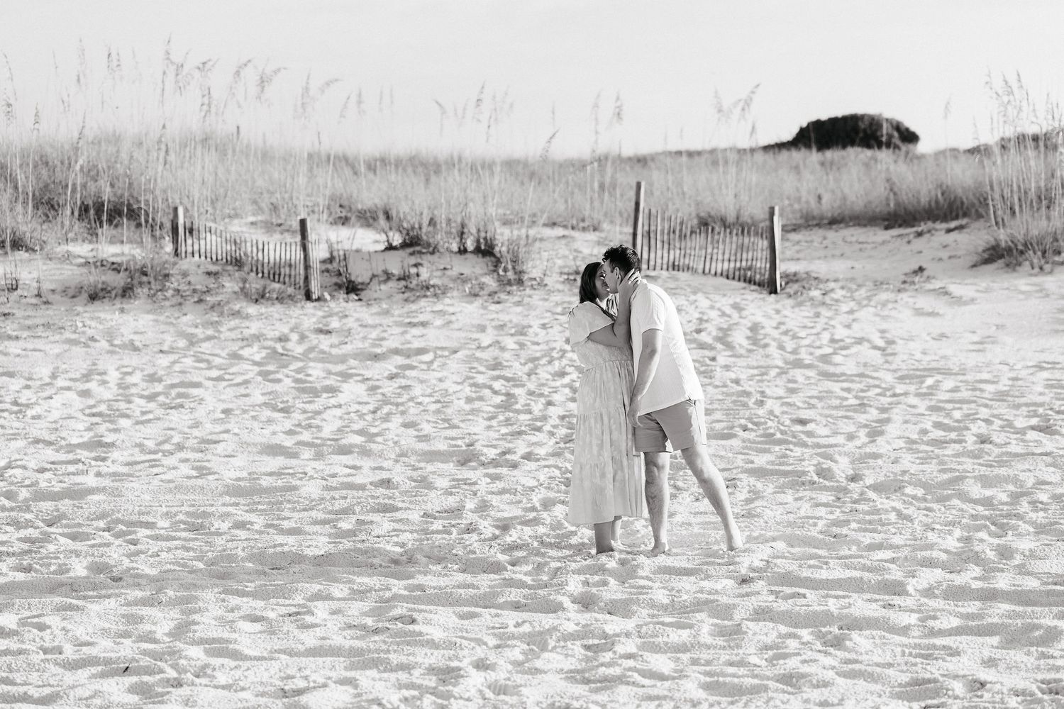 Seven black and white photographs showing a dog playing and running on a sandy beach.