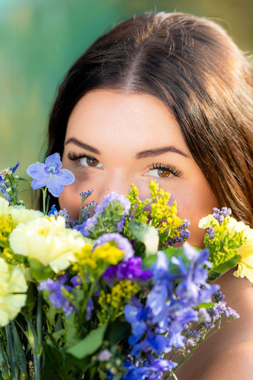 A series of five close-up shots showing eyes peeking above a colorful bouquet of blue, yellow and white flowers.
