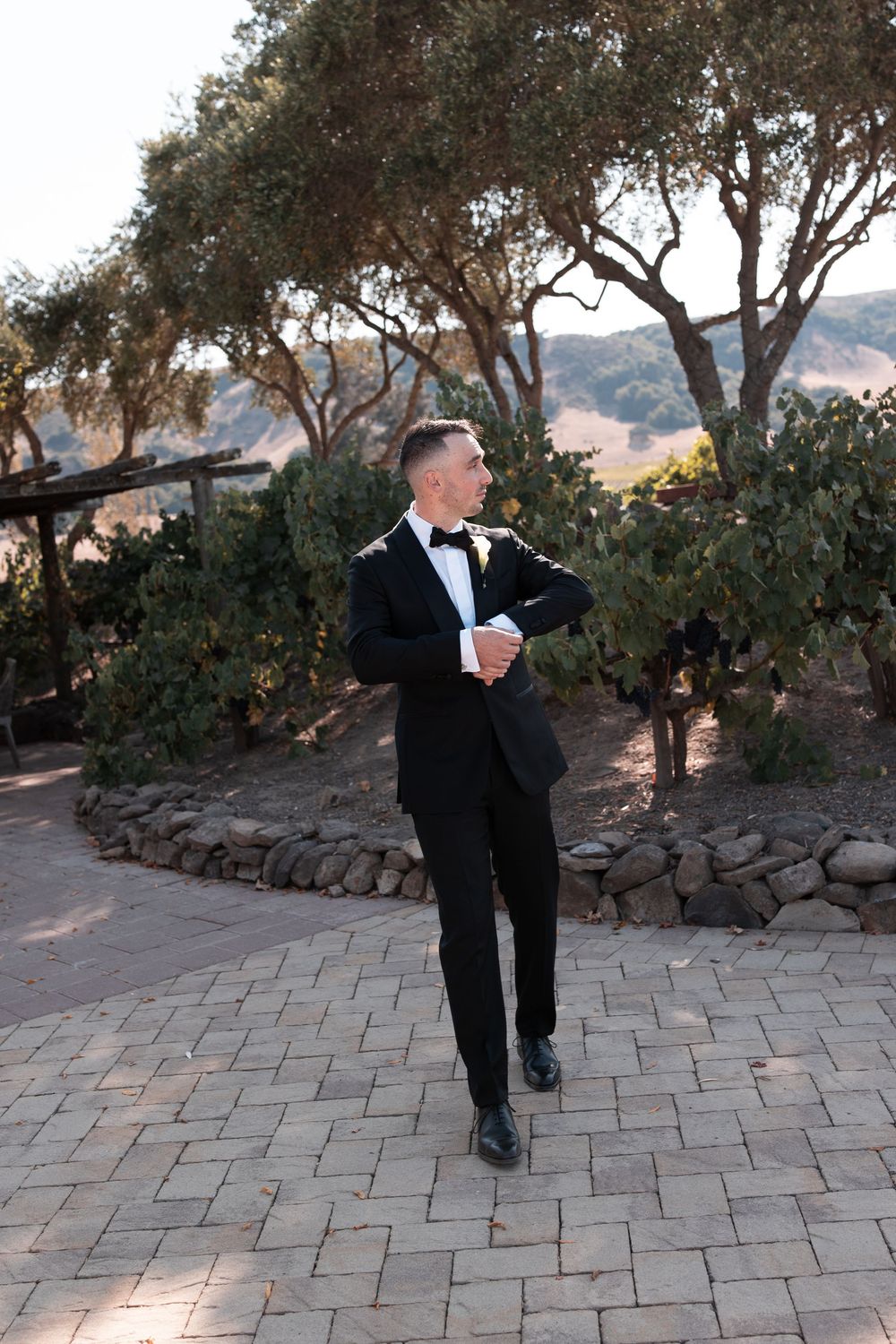A sequence of photos showing someone in a black tuxedo performing dance moves on a stone patio at sunset.