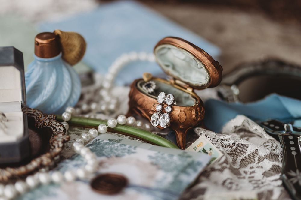 Vintage wedding rings and jewelry arranged on delicate lace with soft lighting and romantic styling.