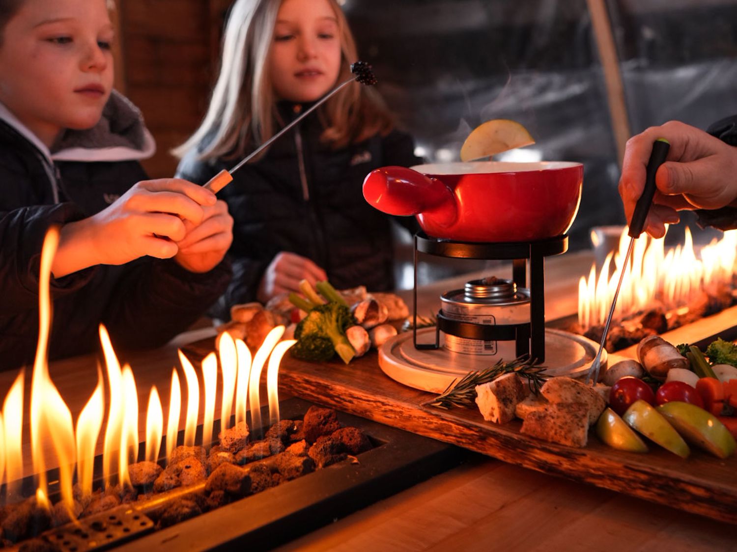 Lit birthday candles glowing warmly on a cake in a dark room create a festive celebration atmosphere.