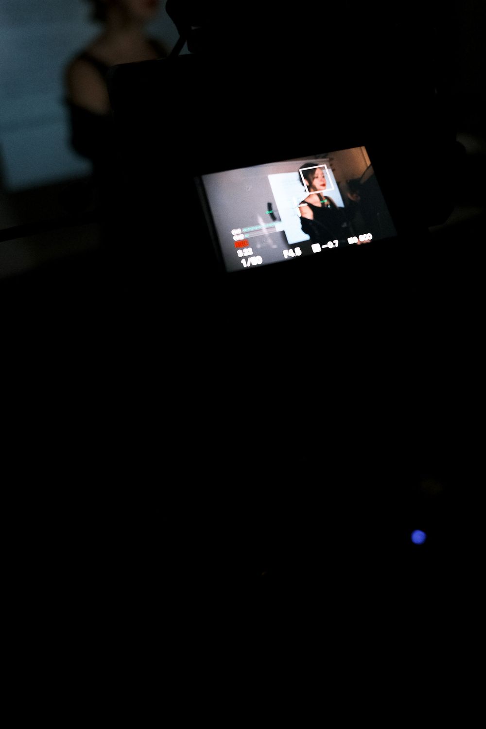 A dark screen displays a small video playback interface with minimal illumination in the corner.