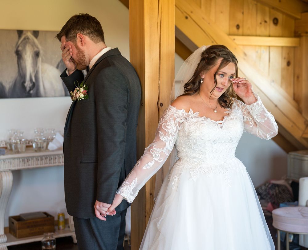 A couple shares intimate moments in a rustic wooden barn interior during their wedding celebration.