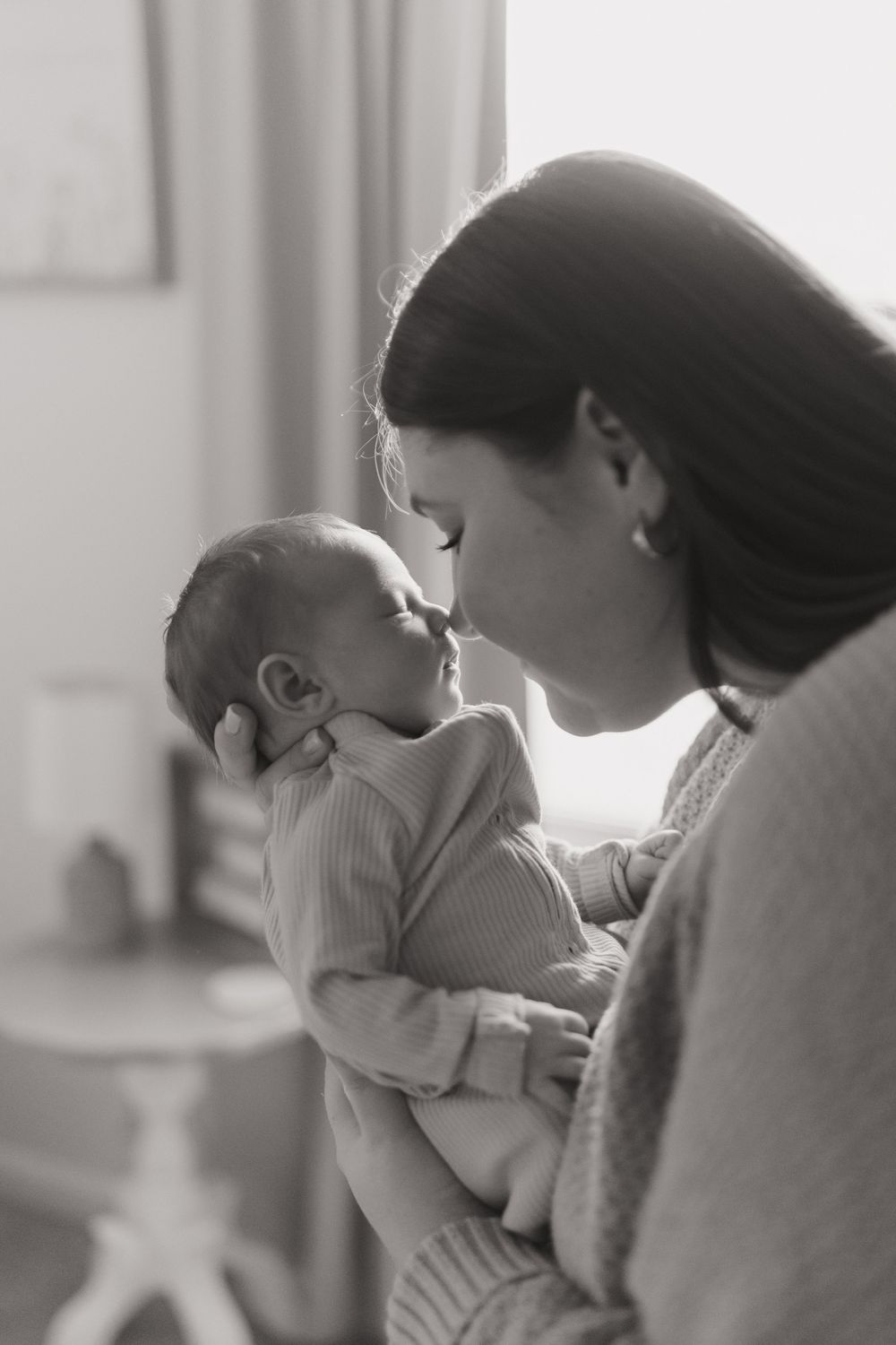 Black and white series capturing intimate moments between parent and infant in soft natural light.