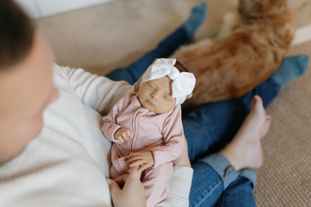 A series of close-up shots showing someone holding and interacting with a small baby's hands and feet.
